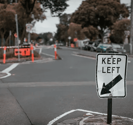 Construction zone traffic sign indicating to keep left on a city street.